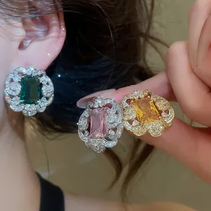 Macro detail of luxury zircon stud earrings with square gemstones in intricate lace settings