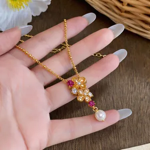 Elegante Nahaufnahme einer Vintage-Blumenkette mit roten Zirkonen und einem weißen Perlenanhänger