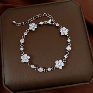 Close-up of elegant camellia bracelet with sparkling zirconia flowers on brown box