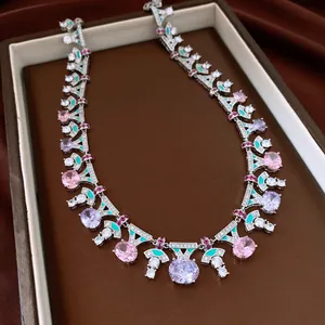 Macro view of vintage silver necklace with pink and purple zircons and teal enamel.