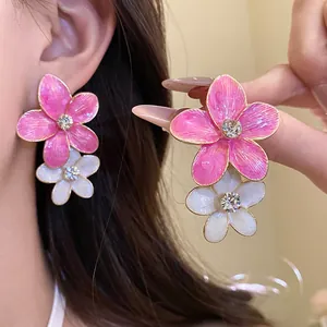Detailed view of pink and white drip oil flower drop earrings with rhinestone center