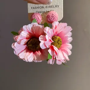 Elegant pink raffia fabric flower stud earrings with a stylish silver needle design.