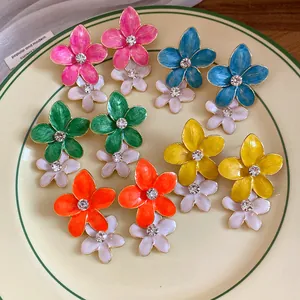 Detailed view of vibrant enamel flower earrings with sparkling rhinestone center