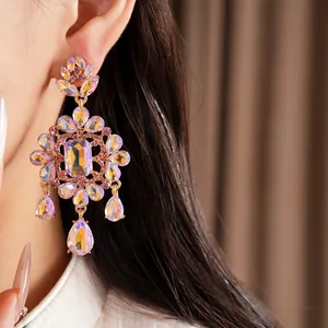 Detailed close-up of palace-style iridescent crystal teardrop earrings on model
