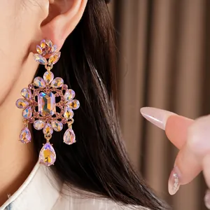 Macro view of ornate court-style earrings with iridescent crystals and teardrop dangles