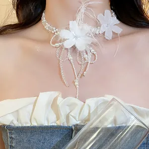 Detailed view of an elegant white feather flower pearl choker worn by a model