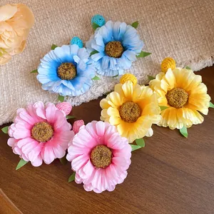 Detailed view of colorful raffia fabric flower earrings in blue, yellow, and pink
