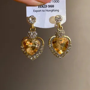 Dettaglio di orecchini a cuore vintage eleganti con castoni in cristallo ambrato