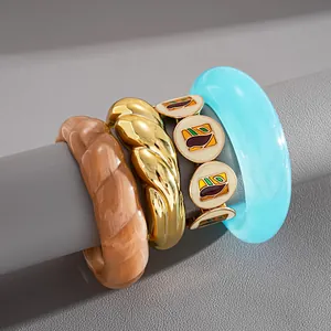 Vue détaillée de divers bracelets en résine marbrée et métal doré sur un présentoir