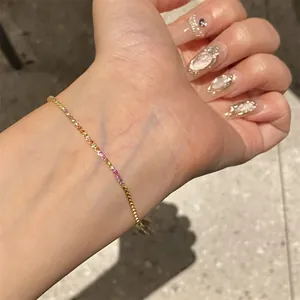 Detailed view of 18k gold plated bracelet with multi-color zircon stones on wrist.