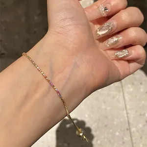 Detailed view of elegant gold-plated rainbow zircon bracelet on wrist with styled nails