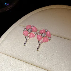 Dettaglio ravvicinato di eleganti orecchini a cuore rosa con strass e perni in argento.