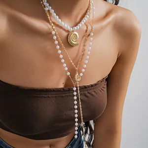 Detailed view of a three-piece layered pearl necklace set with a golden shell pendant