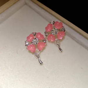 Primo piano di orecchini a forma di cuore rosa con strass e perni in argento