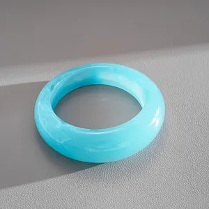 Vue détaillée d'un bracelet jonc moderne en résine bleue marbrée à texture nuageuse