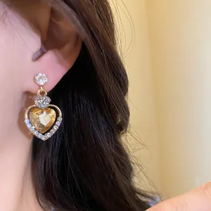 Primo piano dettagliato di orecchini a cuore in stile vintage con pietra ambrata