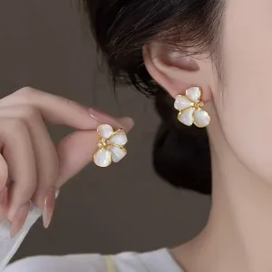 Detailed view of elegant French style white flower earrings with zircon center