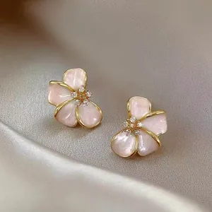 Detailed macro view of pink enamel flower earrings with sparkling zircon centers
