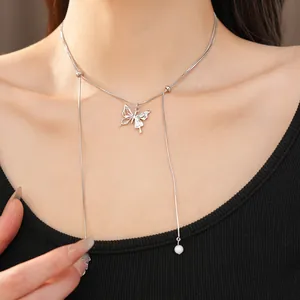 Detail view of silver butterfly necklace with long tassels and pearl drop