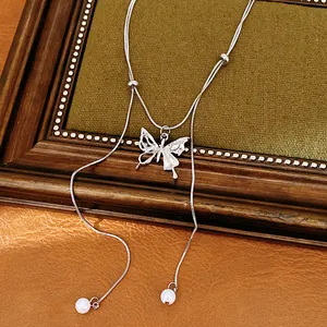 Macro view of a silver butterfly pendant necklace with double layers and pearl tassels