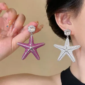 Dettaglio di orecchini a stella marina con zirconi cubici rosa e bianchi brillanti.
