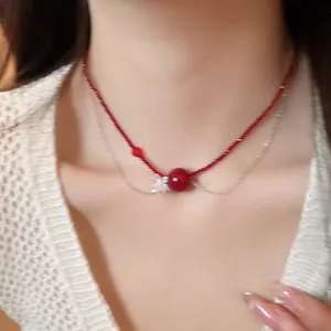 Dettaglio ravvicinato di collana a due strati con perline di cristallo rosse e fiore