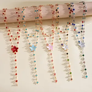 Detailed view of colorful Y-shaped necklaces with resin flower pendants and rhinestones