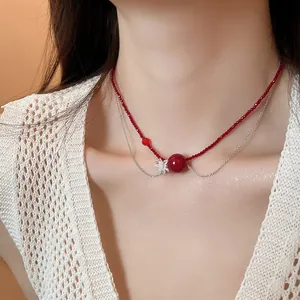 Dettaglio di una collana a due strati con perline di cristallo rosso e catena d'argento