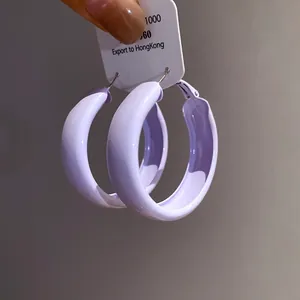 Detailed macro view of lavender painted thick hoop earrings with silver needle posts