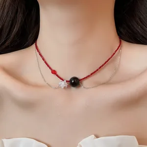 Vista dettagliata di una collana a due strati con perle di cristallo rosse e fiore