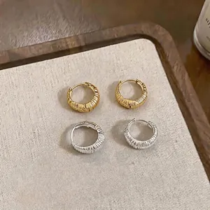 Eleganti orecchini a cerchio a U testurizzati in finiture oro e argento lucido