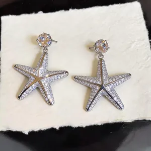 Dettaglio degli orecchini a perno a forma di stella marina in argento con zirconi