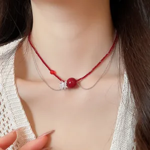Primo piano di una collana a due strati con perle di cristallo rosse e fiore chiaro