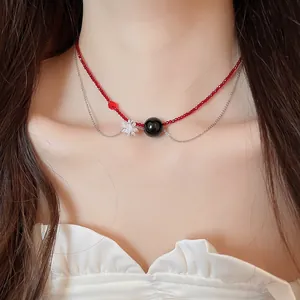Dettaglio ravvicinato di una collana girocollo a due strati con perline rosse e fiore di cristallo