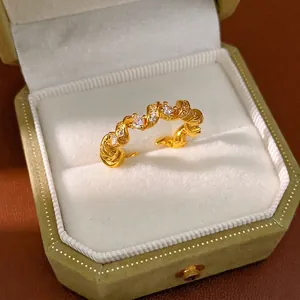 Bague torsadée élégante en or avec pierres de zircone dans un coffret à bijoux en velours