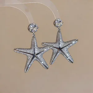 Eleganti orecchini a stella marina in argento con zirconi scintillanti in dettaglio