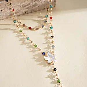 Detailed view of the white resin flower pendant with multi-colored gemstone beads