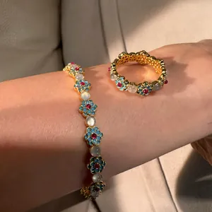 Close-up of vintage floral bracelet and ring set with blue enamel and cat's eye stones
