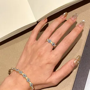 Close-up of vintage flower bracelet and ring with zircon and opal on a model's hand.