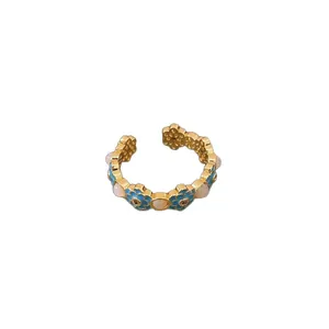Exquisite gold-plated open ring featuring blue enamel floral design and cat eye stones