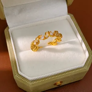 Gros plan d'une bague dorée torsadée sertie de zircons dans un écrin en velours chic