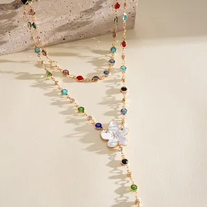 Macro detail of a sweet holiday style necklace with colorful gems and resin flower