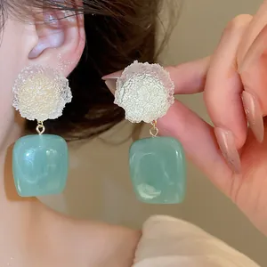 Close-up of the elegant resin frosted flower earrings with translucent sage green pendants