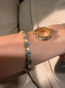 Close-up of elegant flower design bracelet and ring set with zircon and cat's eye stone.