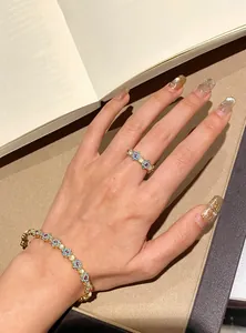 Close-up detail of a light luxury floral zircon cat's eye bracelet and ring set on a hand