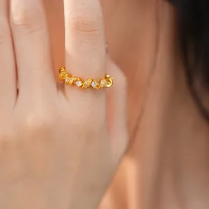 Gros plan d'une bague torsadée en or sertie de zircons cubiques étincelants au doigt