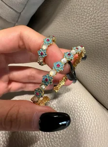 Close-up of vintage floral bangle and ring with blue enamel and cat-eye stones