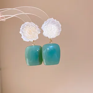 Detailed macro shot of New Chinese style frost flower resin drop earrings in teal color