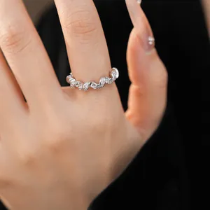 Gros plan d'une bague argentée torsadée élégante avec zircons étincelants au doigt