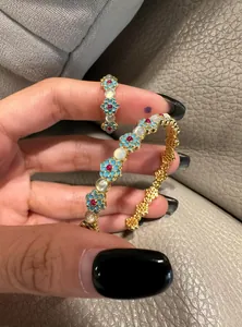Detailed view of vintage gold floral bangle and ring set with cat's eye stones